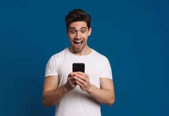 Un homme qui espionne les sms depuis son smartphone