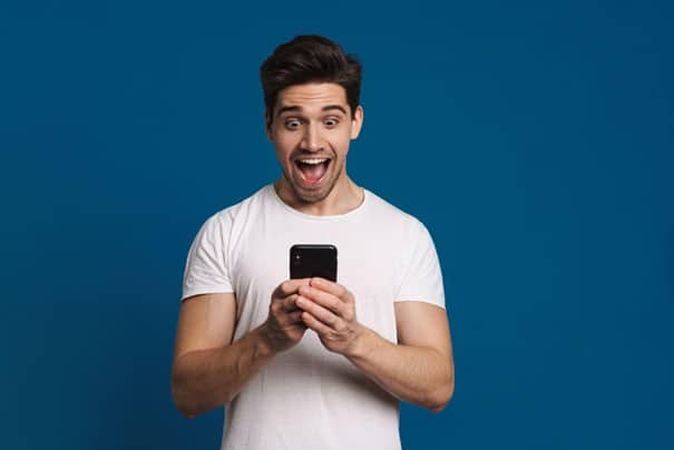 Un homme qui espionne les sms depuis son smartphone